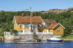 Old cottage with a jetty and boats in the Swedish archipelago